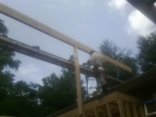 Carpenter setting a ridge beam over a new addition frame — Ice Dam Removal by Roofing Brothers in Groves