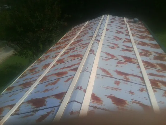 Rusted metal roof panels with new wood purlins before replacement — Storm Damage Roof Repair in Groves by Roofing Brothers